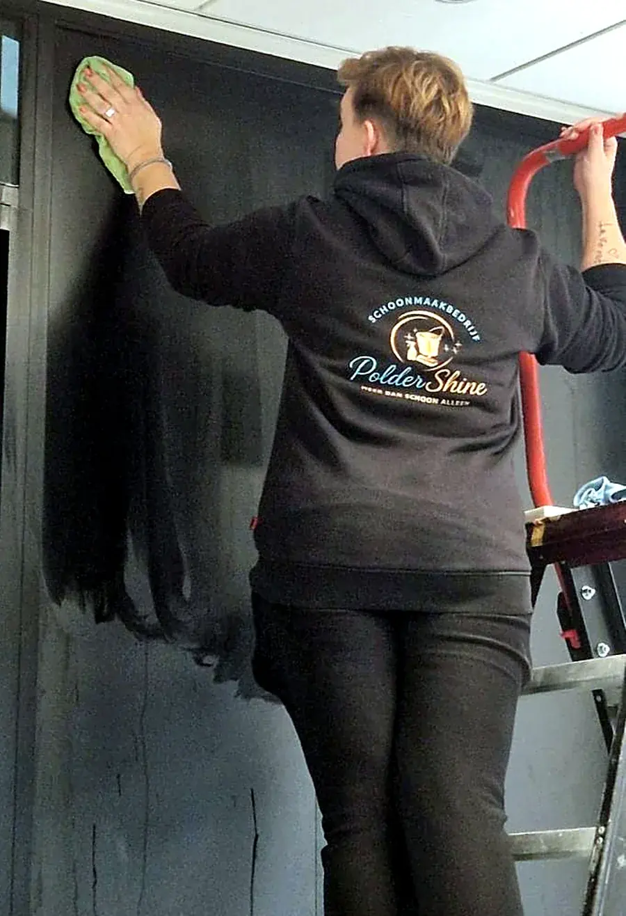 Medewerker van PolderShine reinigt een wand op locatie